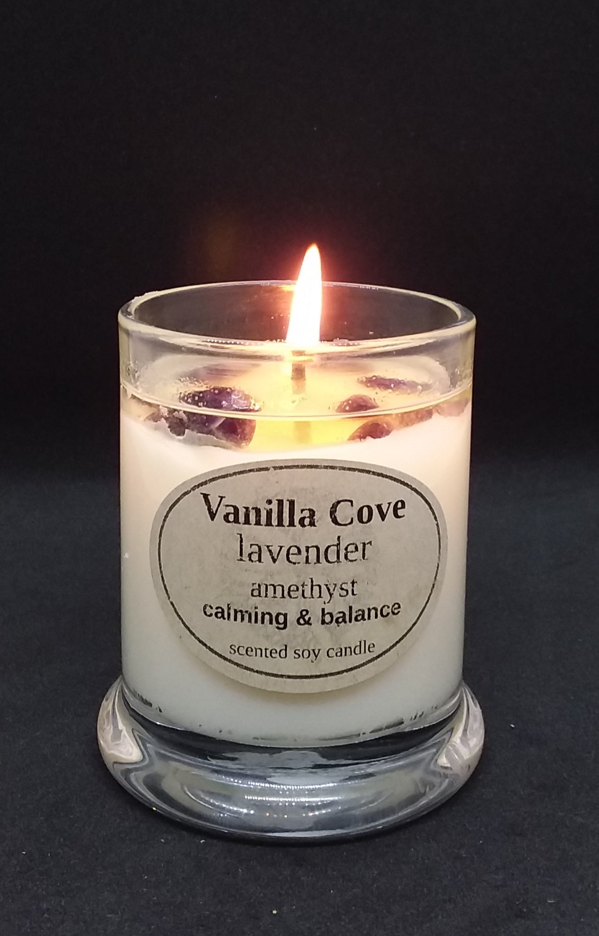 Vanilla Cove Soy Candle 45 hour lavender fragrance with amethyst crystals in clear glass jar and glass lid photo has candle lit